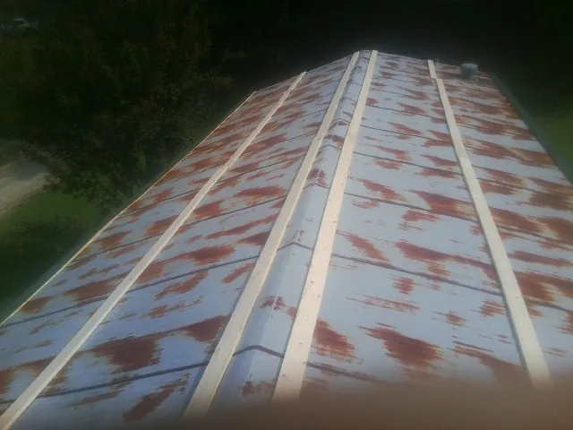 Rusted metal roof panels with new wood purlins before replacement — Storm Damage Roof Repair in Memphis by Roofing Brothers